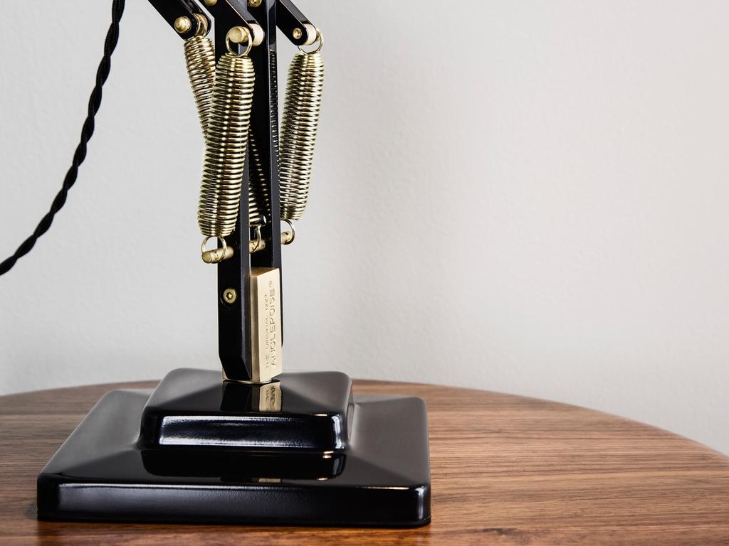Крупный план чёрного квадратного основания лампы Anglepoise с латунными пружинами
