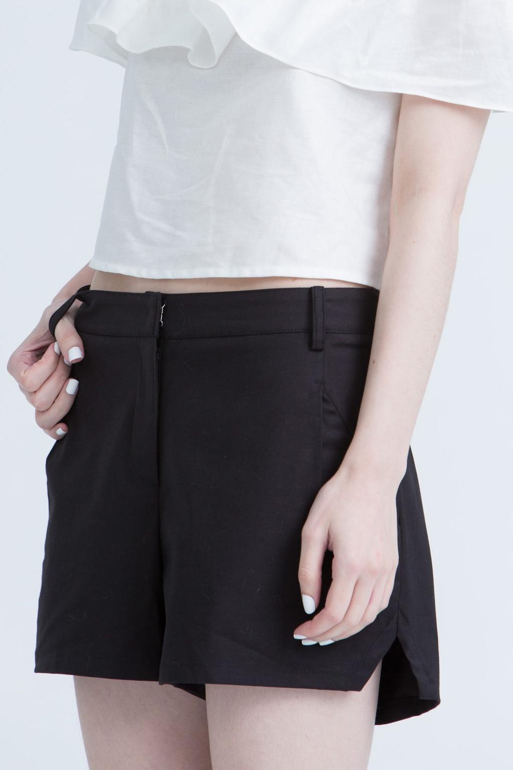 Black Kestan summer shorts and a white cropped top, close-up