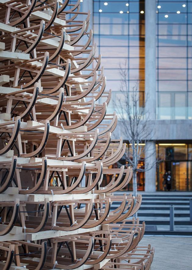 A Christmas tree made of wooden sledges in front of a glazed building façade in Budapest
