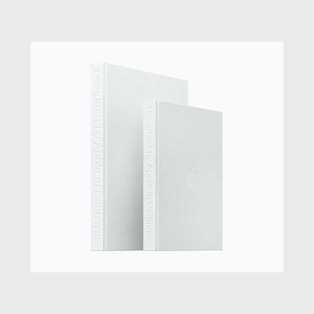 Two white volumes of the book Designed by Apple in California with an embossed title