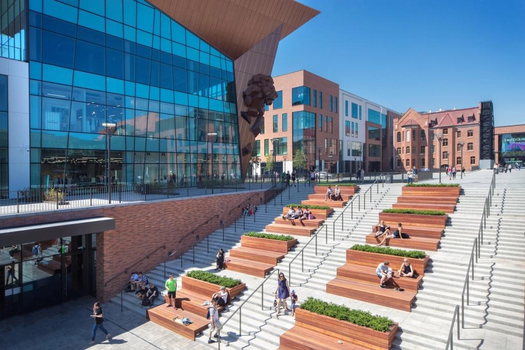 Stepped wooden terraces with greenery beside the glass façade of Forum Gdansk