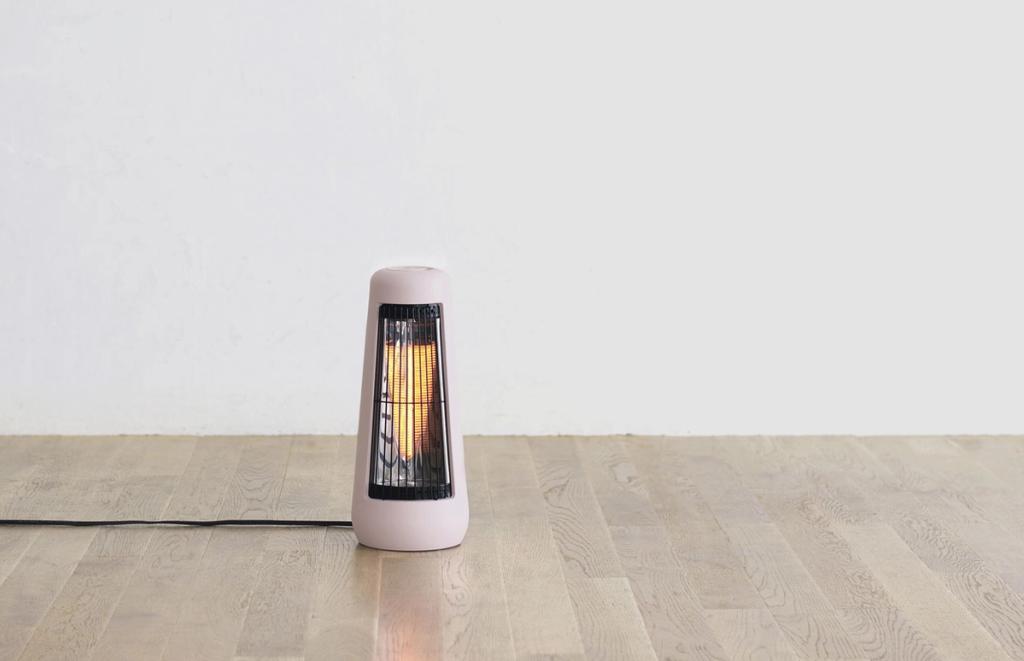 A pink floor-standing infrared heater on a wooden floor