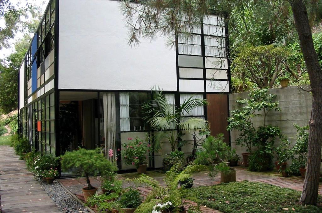 A corner of the Eames House with coloured panels and potted plants in the front garden