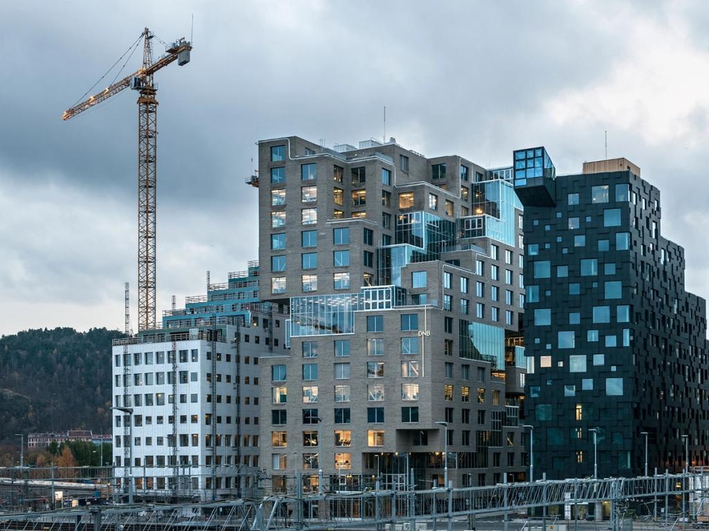 High-rise buildings in the Barcode district of Oslo with a construction crane against an overcast sky