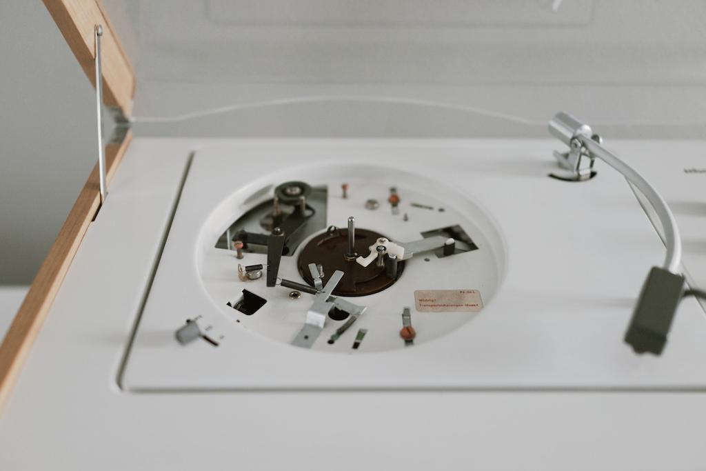 The removed turntable platter reveals the internal mechanism of the Braun record player