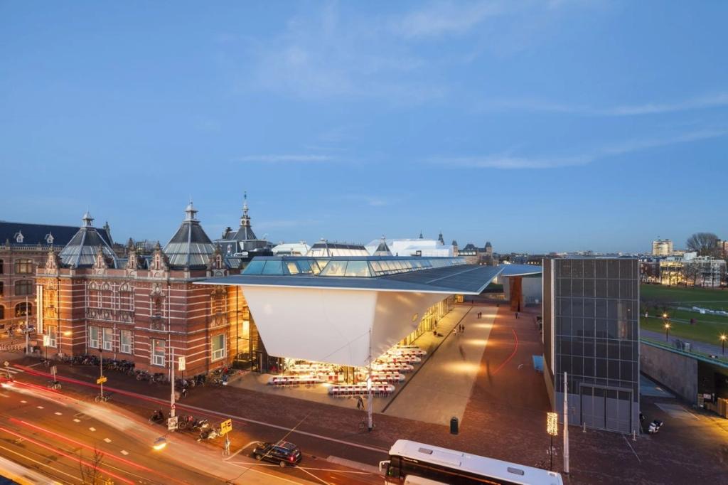 Музей Stedelijk с современной пристройкой и историческим корпусом, вид сверху вечером