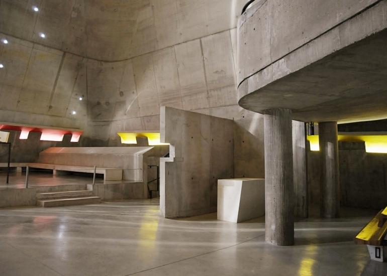 The concrete interior of the church of Saint-Pierre in Firminy, with the altar and bands of coloured light