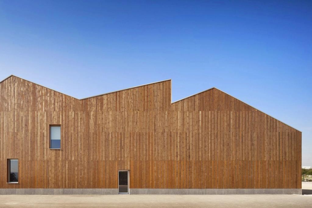 The solid timber façade of Mouriz school with its broken roofline and sparse windows