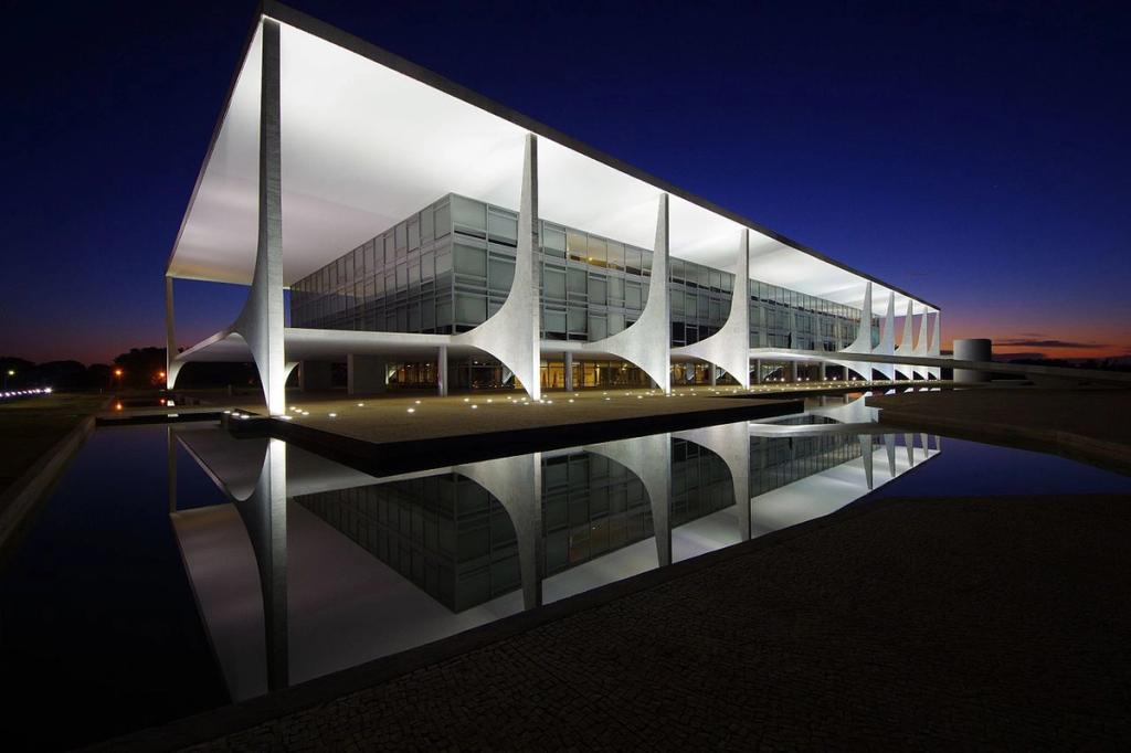 The Palácio do Planalto in Brasília at dusk, its slender curved columns reflected in the water
