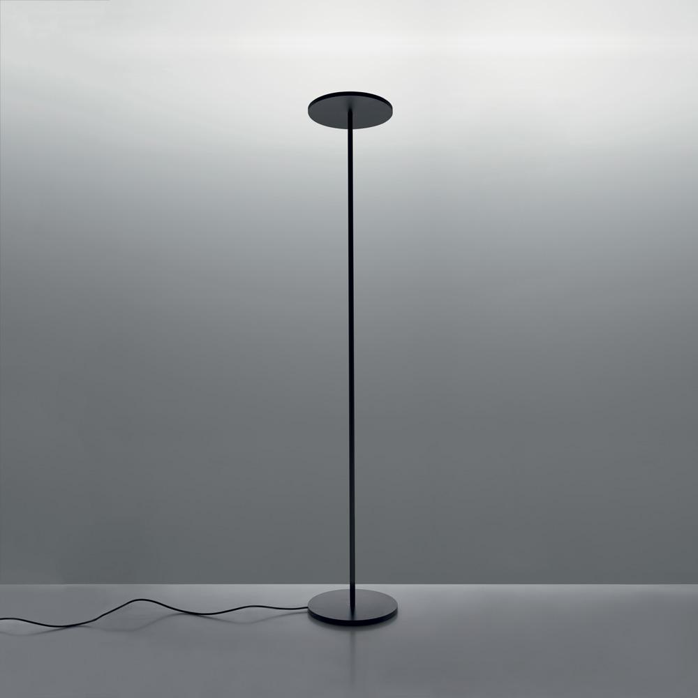 A black floor lamp: a slender stem with a flat circular disc directing light upward