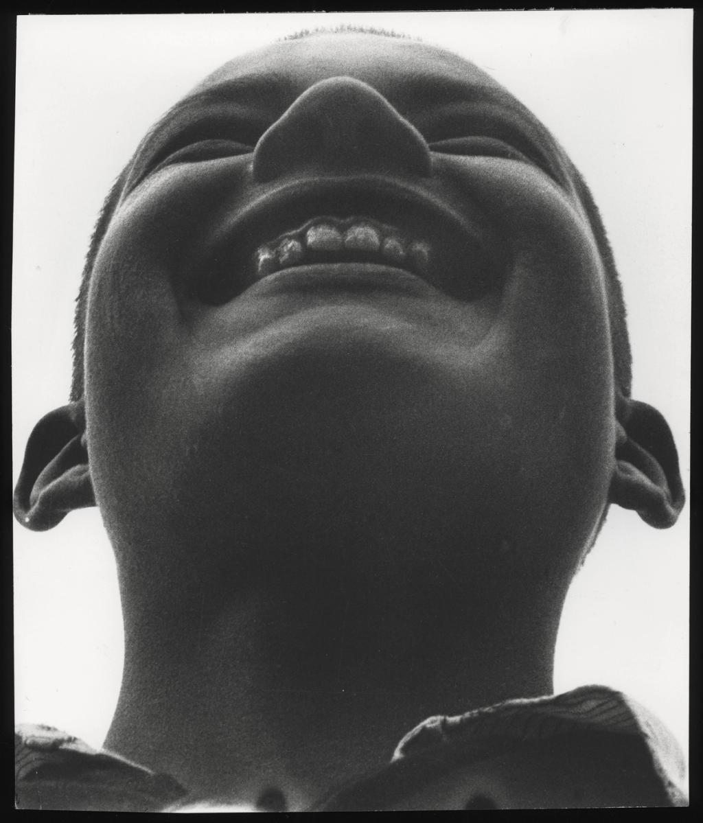 A close-up of a Pioneer's laughing, upturned face, shot from below