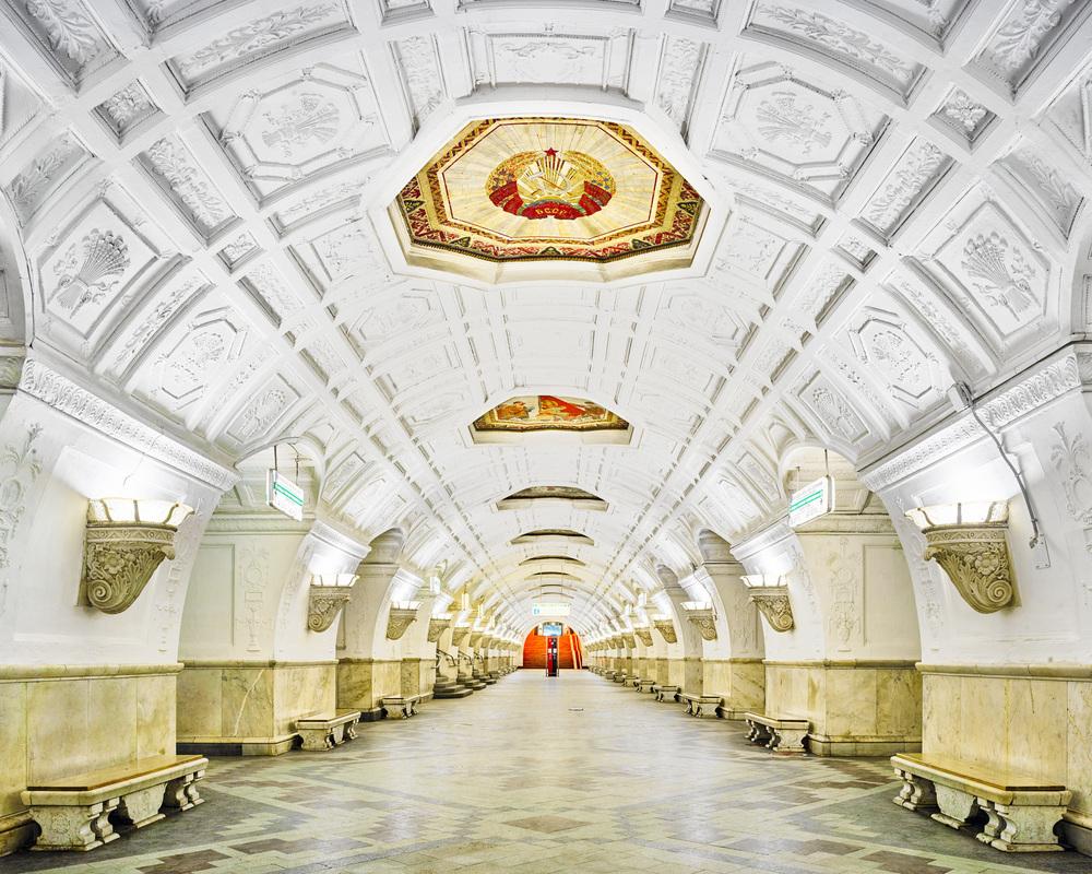 Белая лепная арочная станция метро с мозаичным гербом на потолке