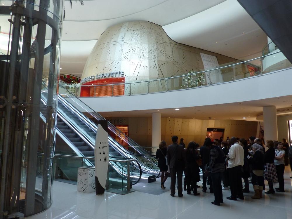 The interior of Morocco Mall with escalators, a lift in a glass shaft and a Galeries Lafayette store