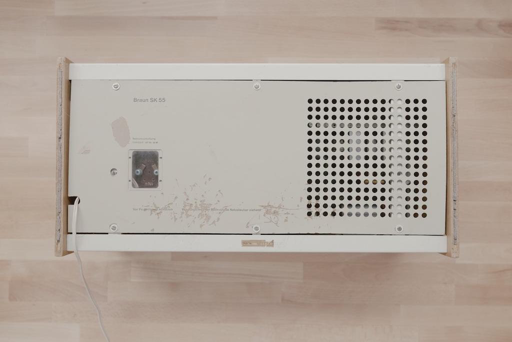 Top view of the removed base of the Braun SK55, showing labelling and perforations, on a wooden floor