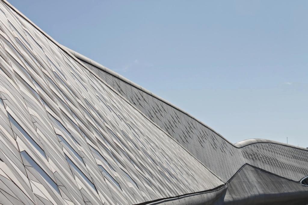 A detail of the grey scaled cladding of the Zaragoza bridge-pavilion against a blue sky