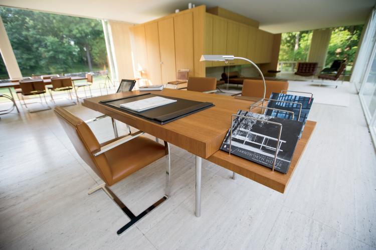 Interior of the Farnsworth House with a table, leather armchairs, and a book about the house on the table