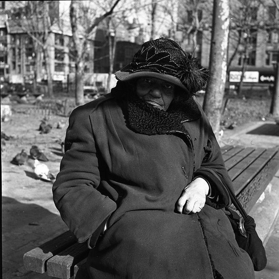 An elegant woman in a light coat against the steps of the New York Public Library