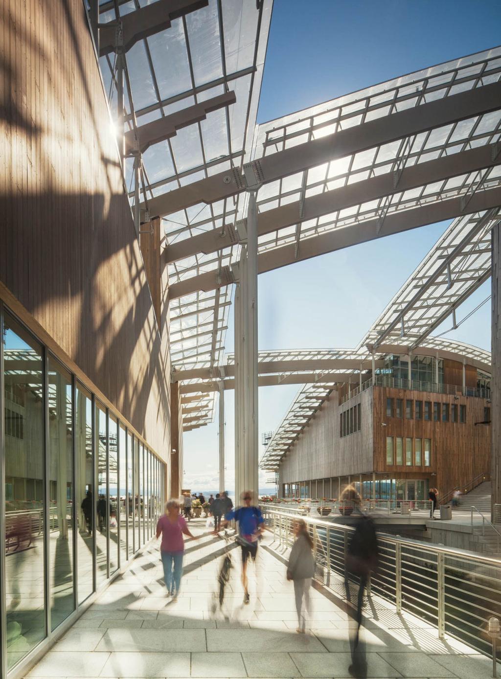 The timber gallery beneath the sail-shaped glass roof of the Astrup Fearnley Museum, with visitors walking along the passage