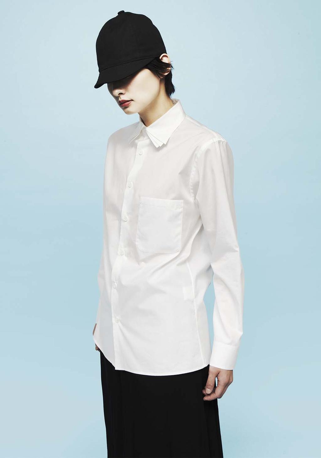 A model in a black cap, white shirt with a patch pocket, and black skirt