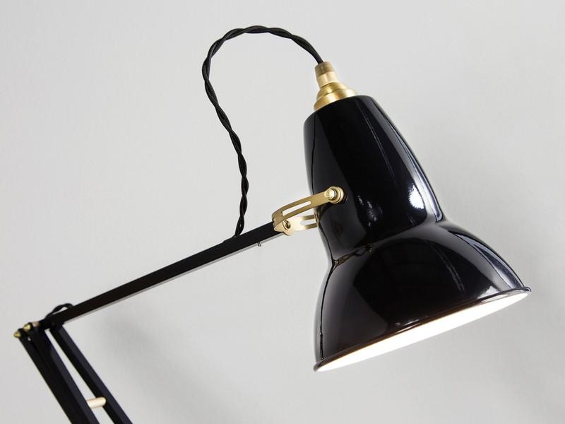 Крупный план чёрного глянцевого плафона лампы Anglepoise с латунными деталями