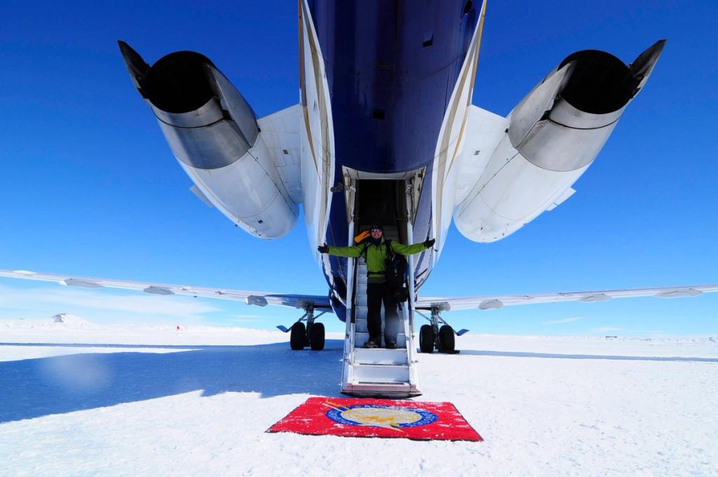 A tourist descends the aircraft steps onto a snow runway in Antarctica