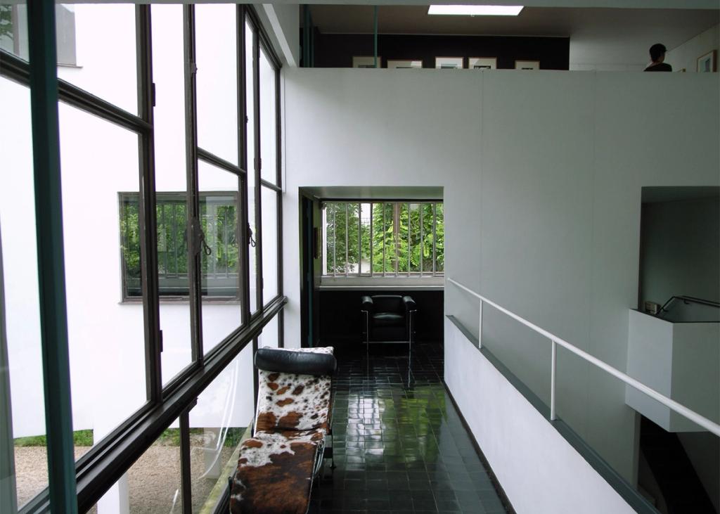 The gallery of Villa La Roche with a black leather chaise longue and tiled floor