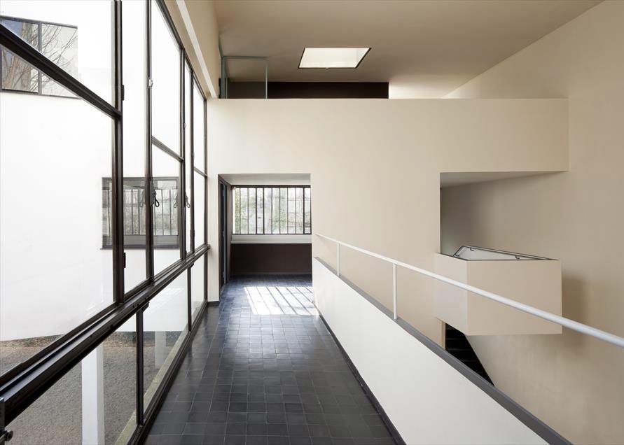 A bright interior corridor at Villa La Roche with ribbon glazing and a tiled floor