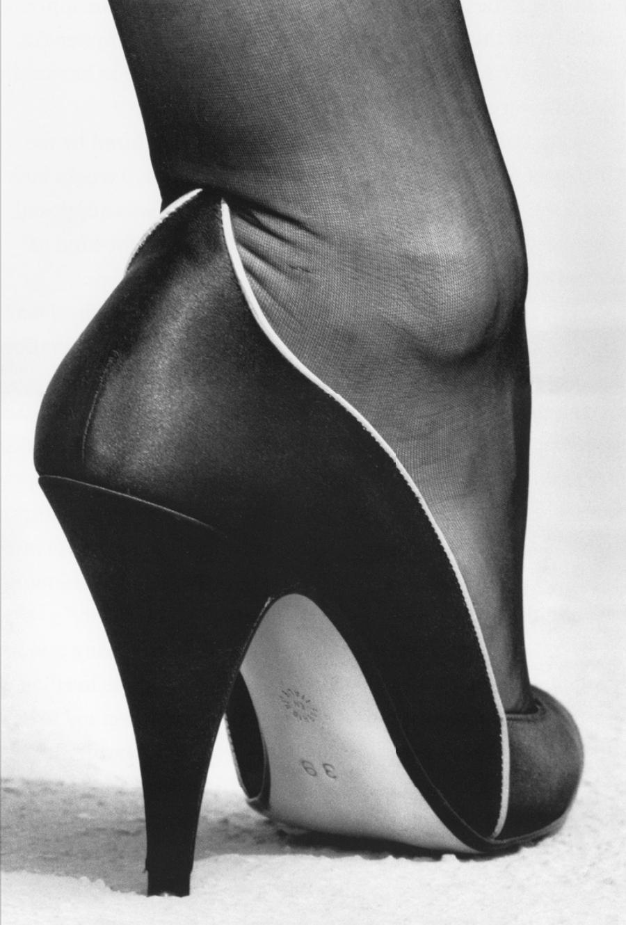 Close-up of a woman's foot in a black high-heeled shoe with the number 39 on the sole