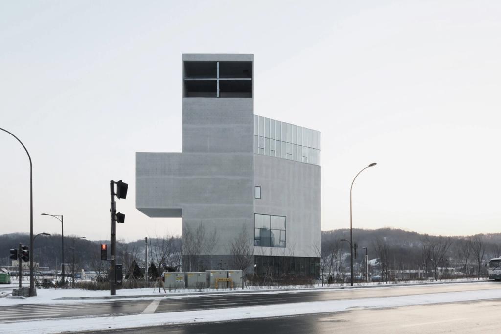 Многоярусный бетонный объём церкви RW Concrete Church на фоне зимнего пасмурного неба