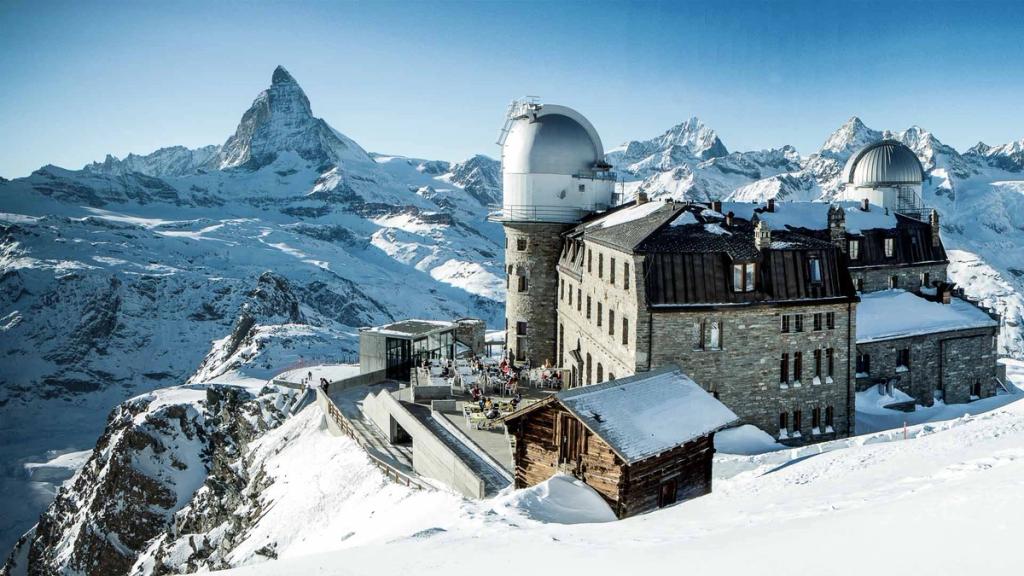 The stone Kulmhotel Gornergrat with its observatory, the Matterhorn rising on the horizon