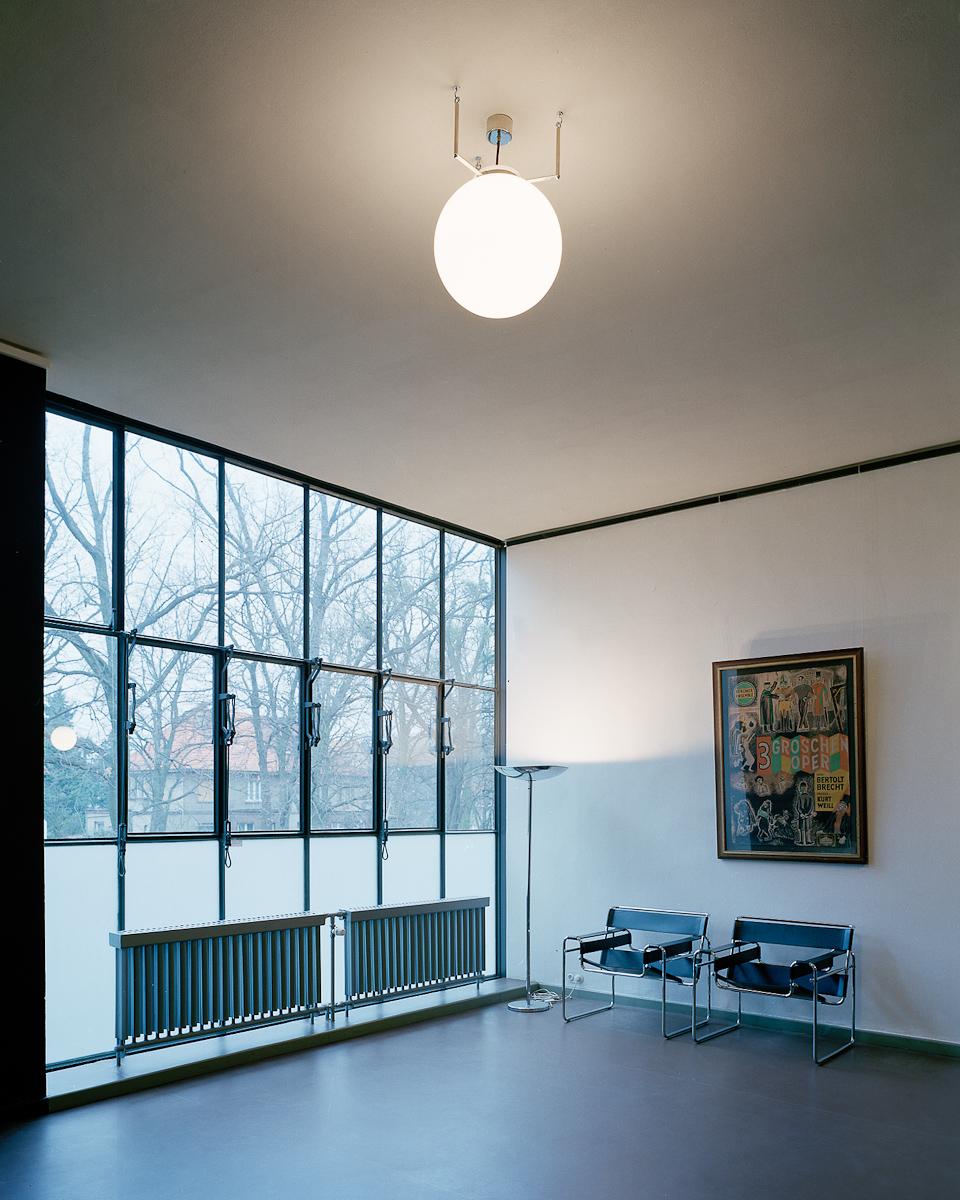 Bauhaus interior with a spherical pendant light, corner glazing and Wassily chairs
