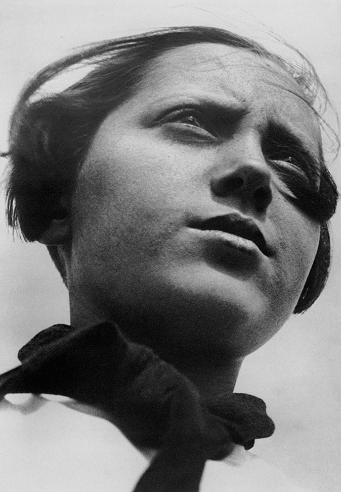 A portrait of a young woman shot from below, her gaze directed into the distance