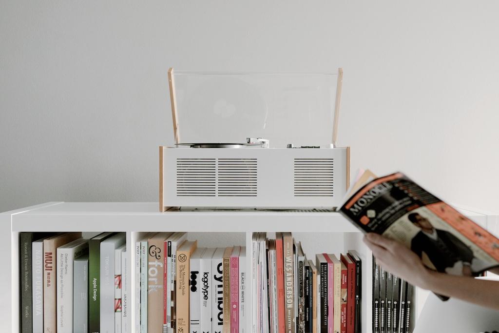 The Braun SK55 record player on a shelf, with a hand leafing through Monocle magazine nearby