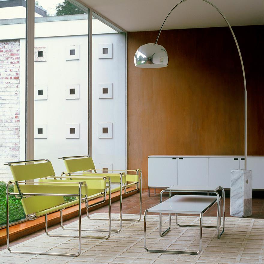 Two yellow Wassily Chairs in an interior with an arc floor lamp and a stone base