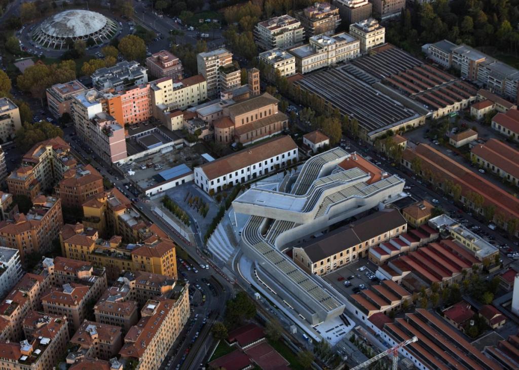 Аэрофотоснимок музея MAXXI с изогнутыми бетонными лентами среди городской застройки Рима