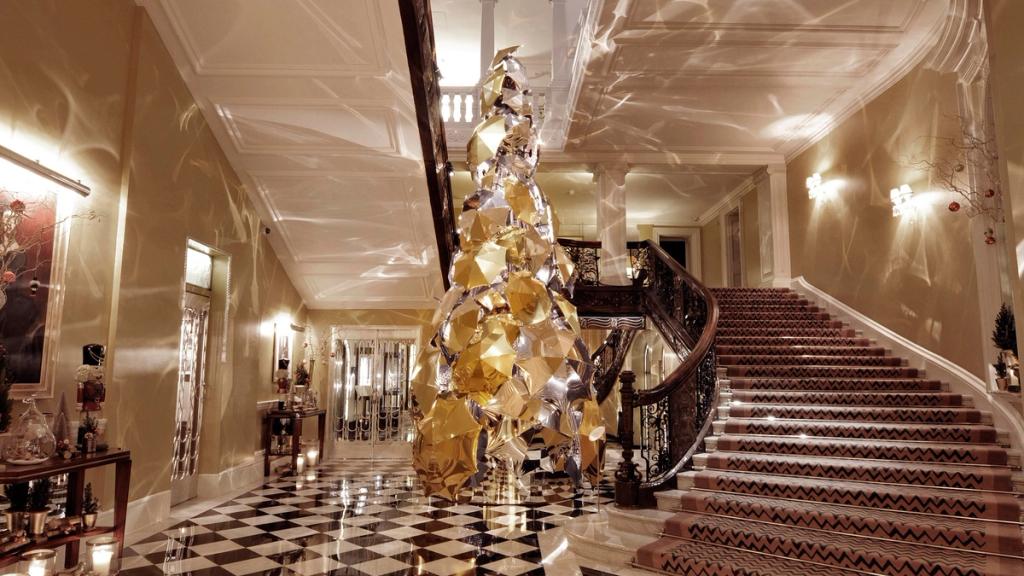 The Burberry tree made of gold and mirrored umbrellas beside a staircase at Claridge's hotel