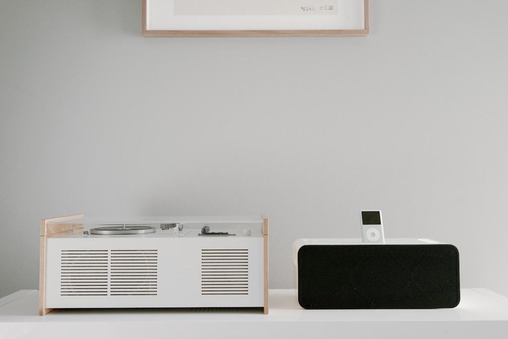 Braun SK55 alongside a modern black speaker and an iPod on a white cabinet