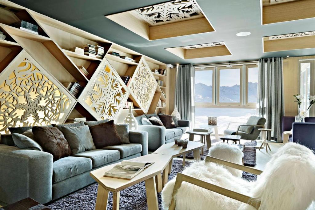 The Altapura lounge with carved latticework panels, sofas and a window onto the snowy mountains