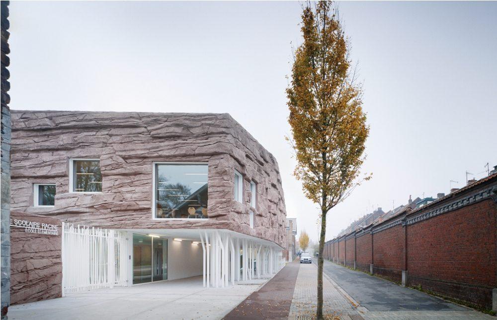 The Roc School: a façade of pink artificial stone with slender white columns along the street