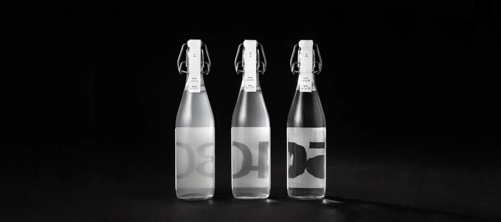 Три бутылки Rice Wine с просвечивающими крупными цифрами на чёрном фоне