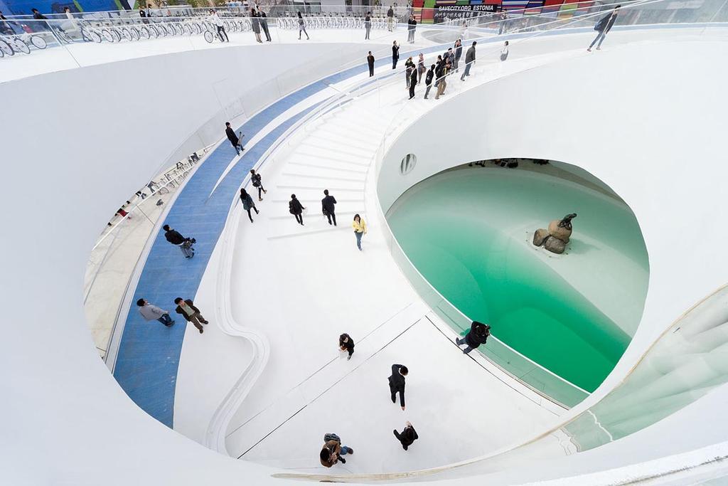 Белый изогнутый интерьер датского павильона на выставке Expo 2010 с винтовым пандусом