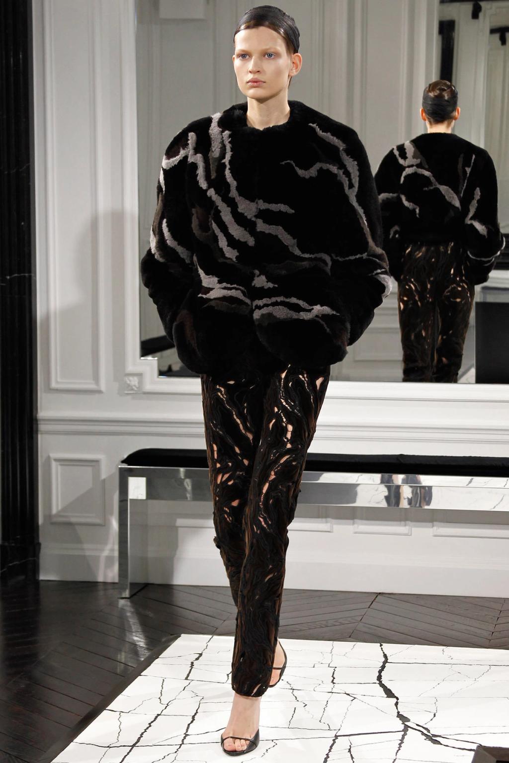 A black Balenciaga fur jacket and trousers with a cutwork pattern on the runway