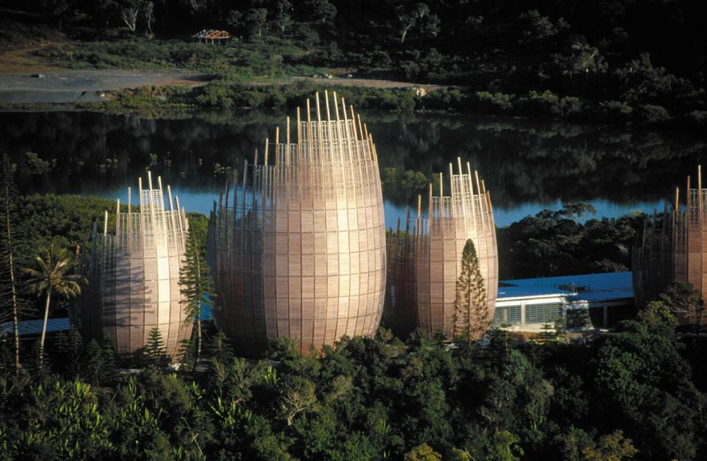 The rounded wooden pavilions of the Jean-Marie Tjibaou Cultural Centre by the water in New Caledonia