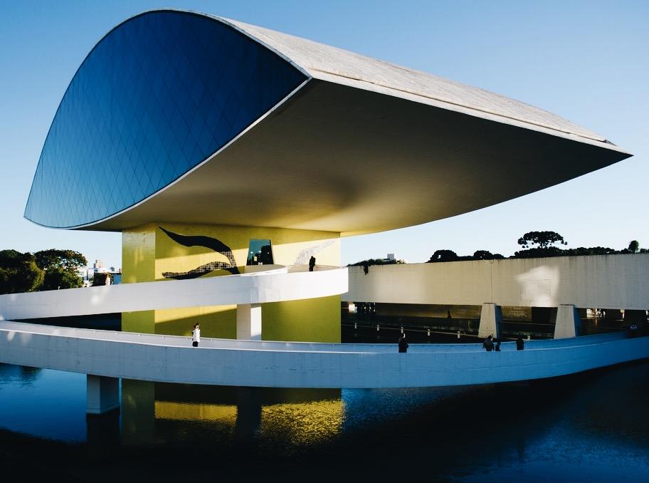 The Oscar Niemeyer Museum in Curitiba, a blue eye-shaped pavilion on a yellow column above water