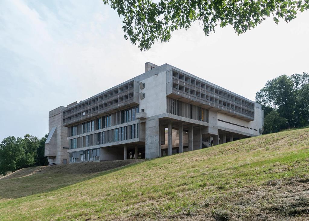 La Tourette Monastery, a concrete bell tower with a cross against a backdrop of trees