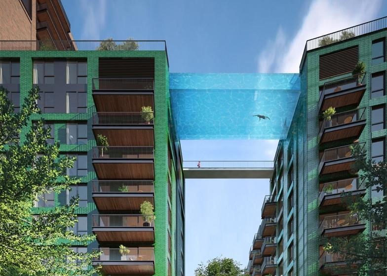 Стеклянный бассейн-мост Sky Pool с пловцом между домами в зелёной кирпичной отделке