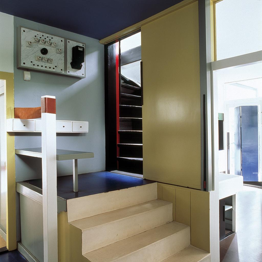 Staircase of the Schröder House with coloured planes and a distribution board on the wall