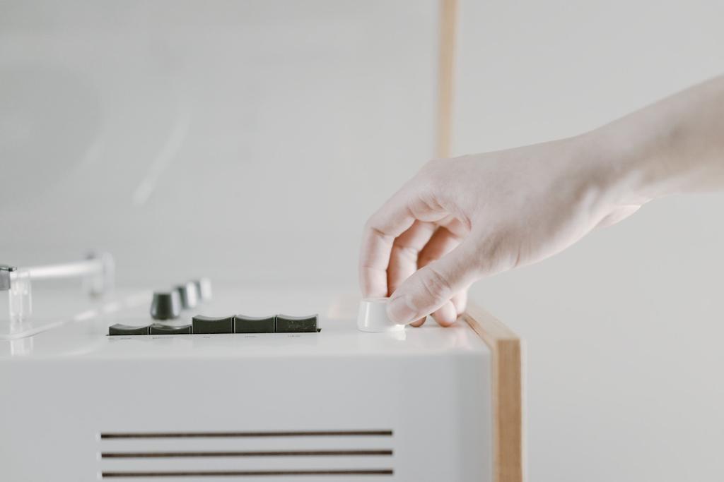 The corner of the Braun SK55's wooden side panel against a white cabinet with a grille, set against a wall