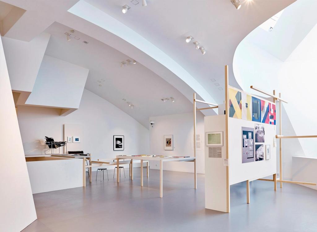 Светлый выставочный зал Музея дизайна Vitra с изогнутыми сводами и работами на стендах