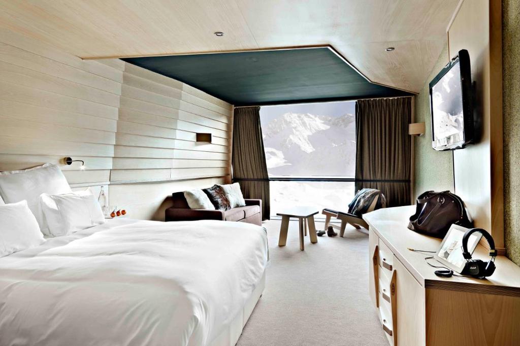 A bright Altapura room with wooden finishes and a window onto the snow-covered slopes